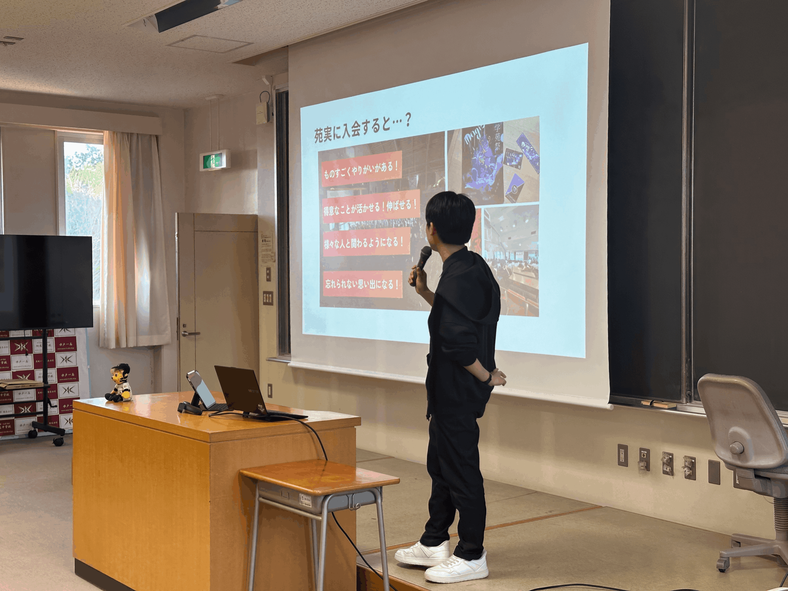 学苑祭実行委員長がスライドを用いて実行委員の説明をしている